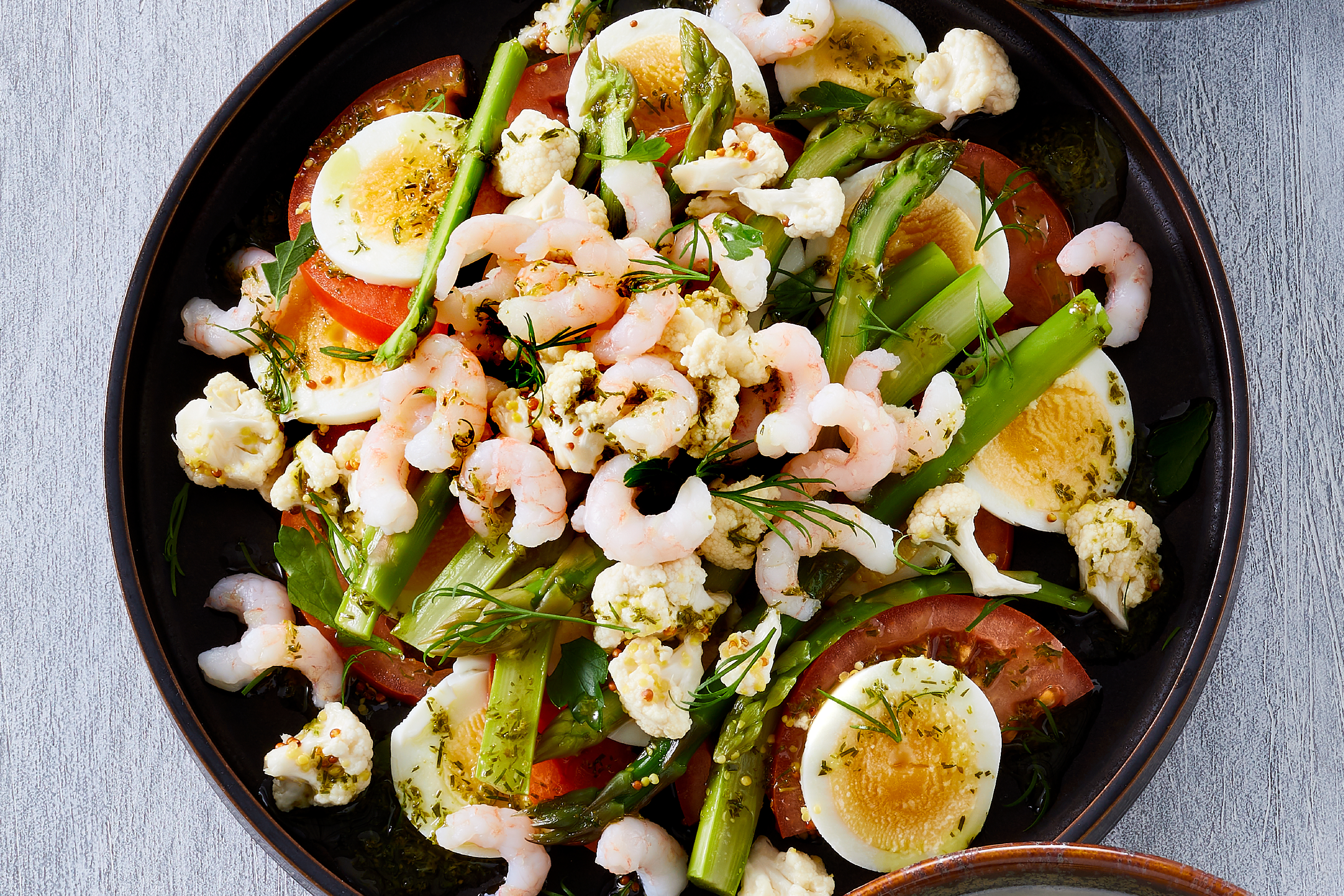 Salat av egg, grønne asparges, tomat, karse og syltede blomkål med limemarinade toppet med grønlandske reker